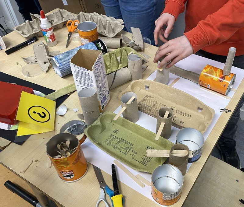 leerlingen werken aan maquette van afval
